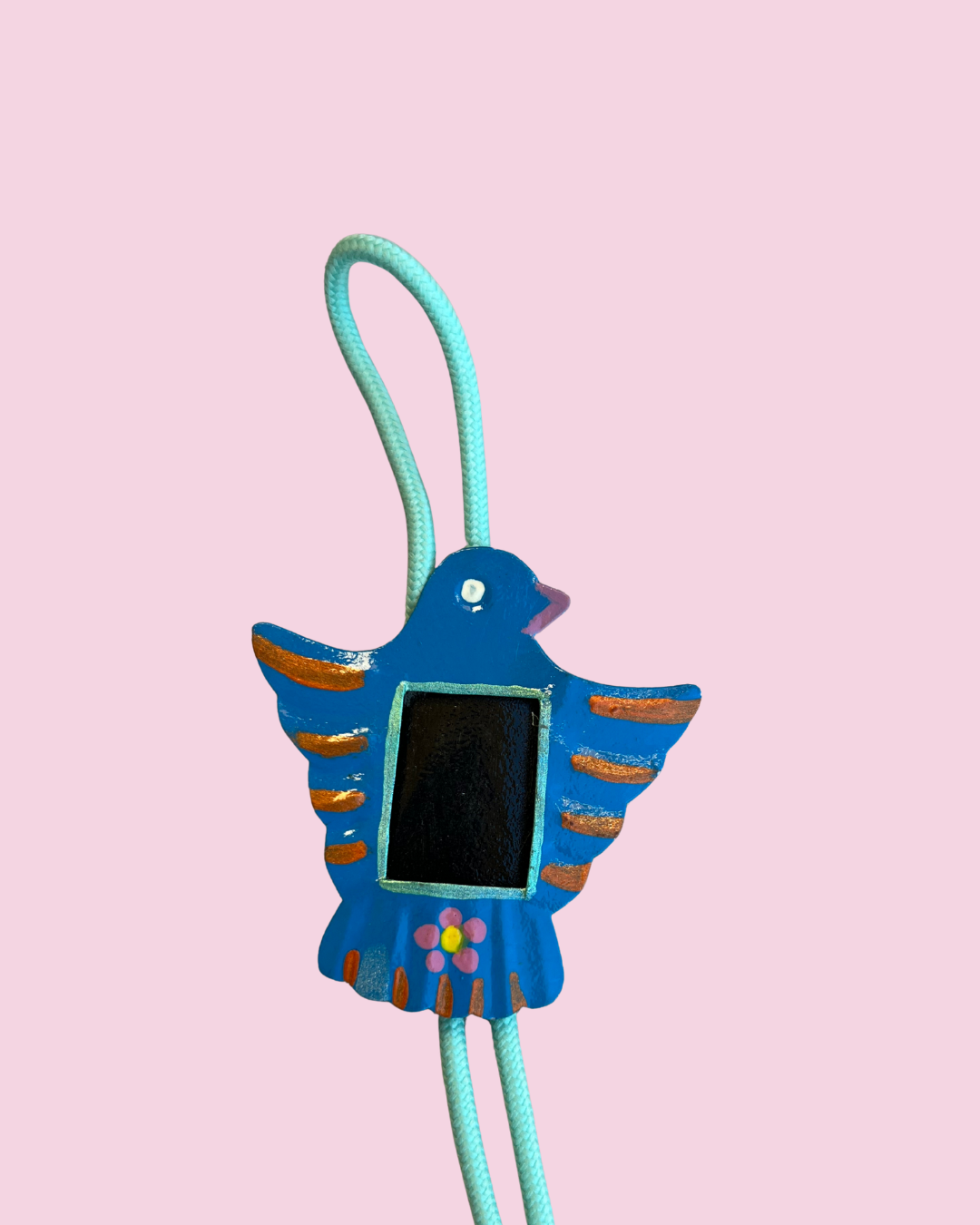 Bird shaped nicho bolo tie pendant on pink background