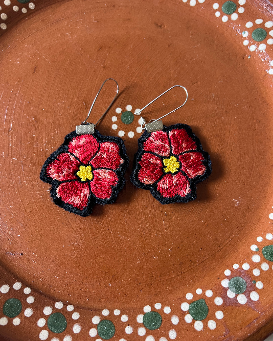 Floral earrings on a decorative brown plate