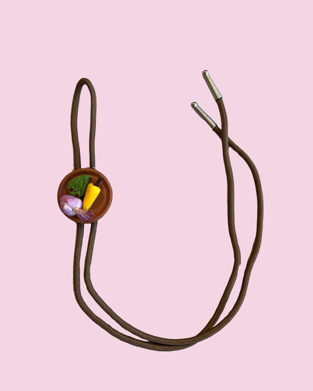 Bolo tie with plate of mexican food pendant on pink background