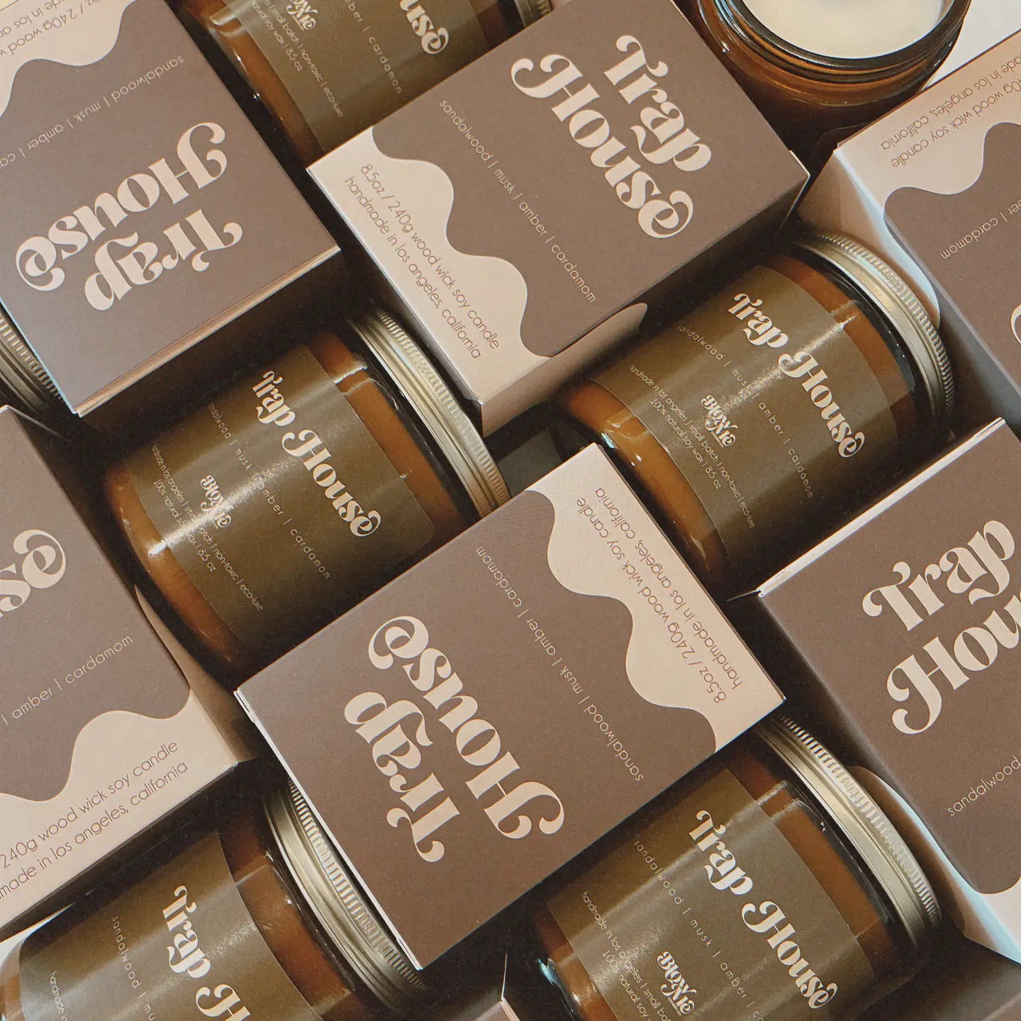 Jars and boxes of Trap House candles arranged in a pattern