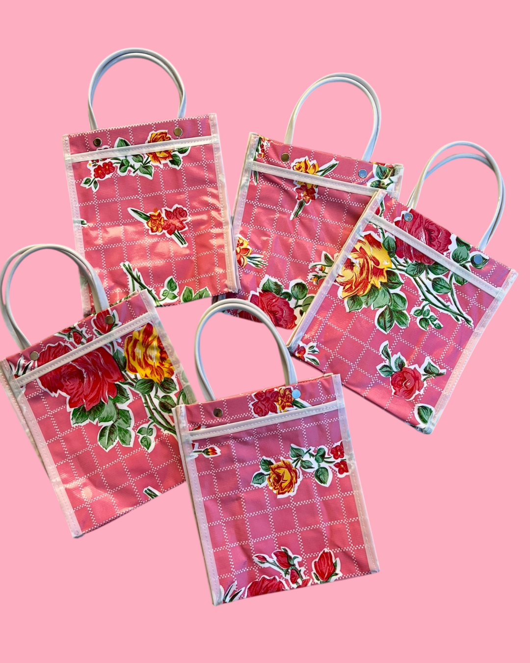 Set of small floral-patterned bags on a pink background