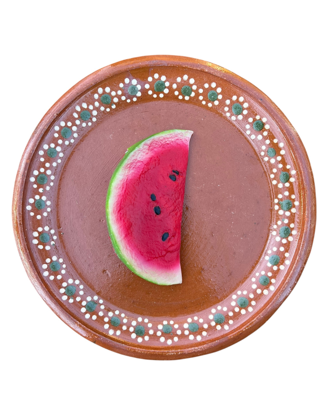 Sliced watermelon coin purse on a decorative ceramic plate with a floral pattern