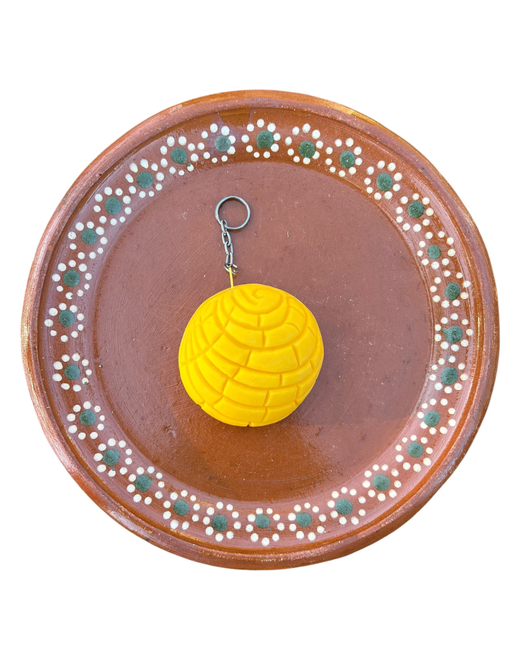 Yellow concha coin purse on barro plate on white background